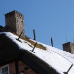 Schneebedecktes Reetdach auf Rügen